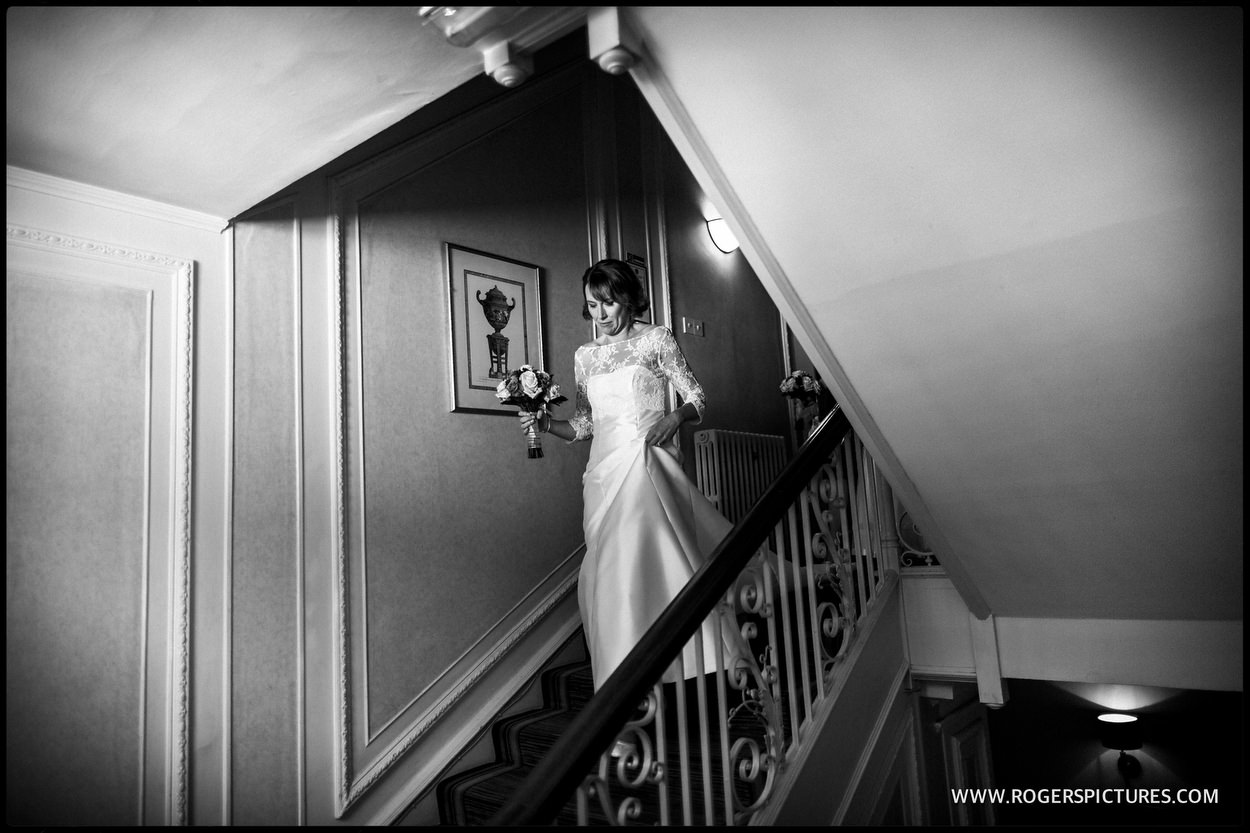 Bride walking down the stairs at Gorse Hill in Surrey