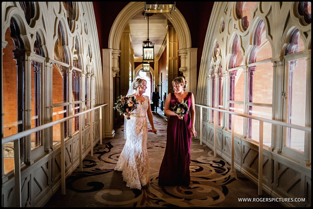 Bride and sister walk along the corridor at St Pancras Hotel