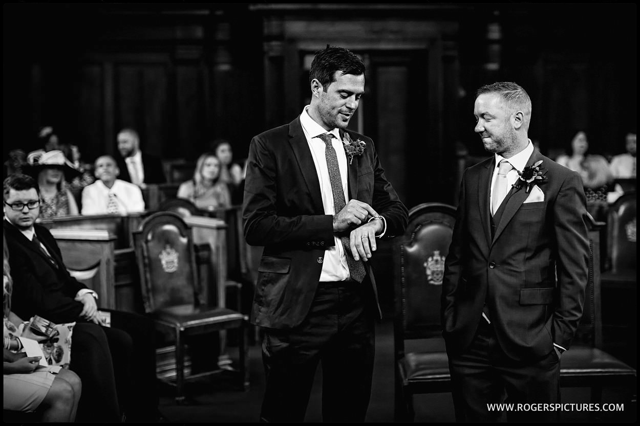 Groom and groomsmen look at watch at Islington town Hall