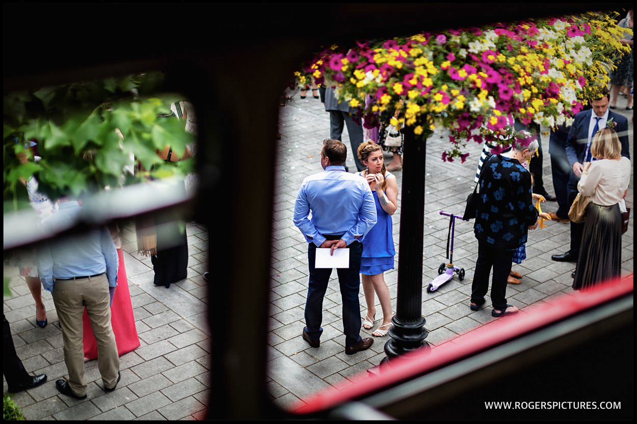 Wedding guests framed in a double-decker bus window