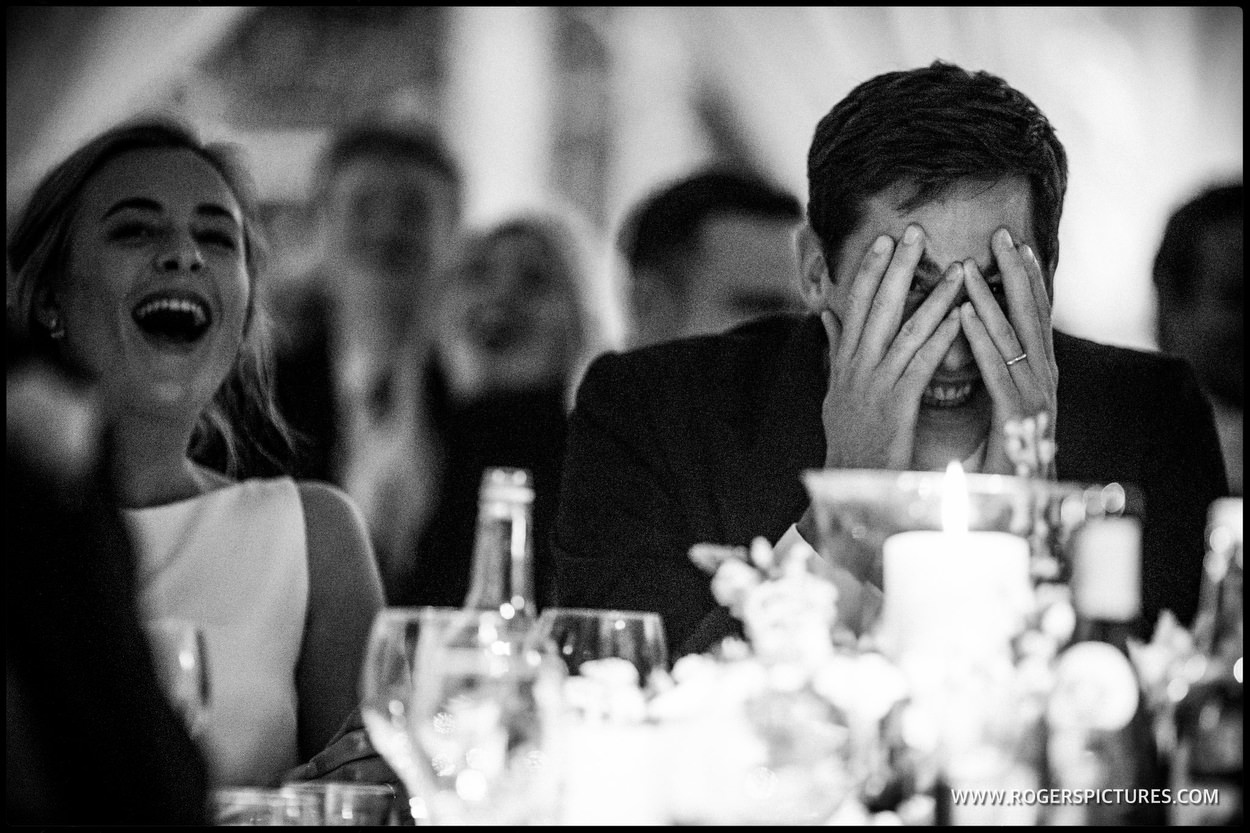 Groom peers out from between his eyes during wedding speeches