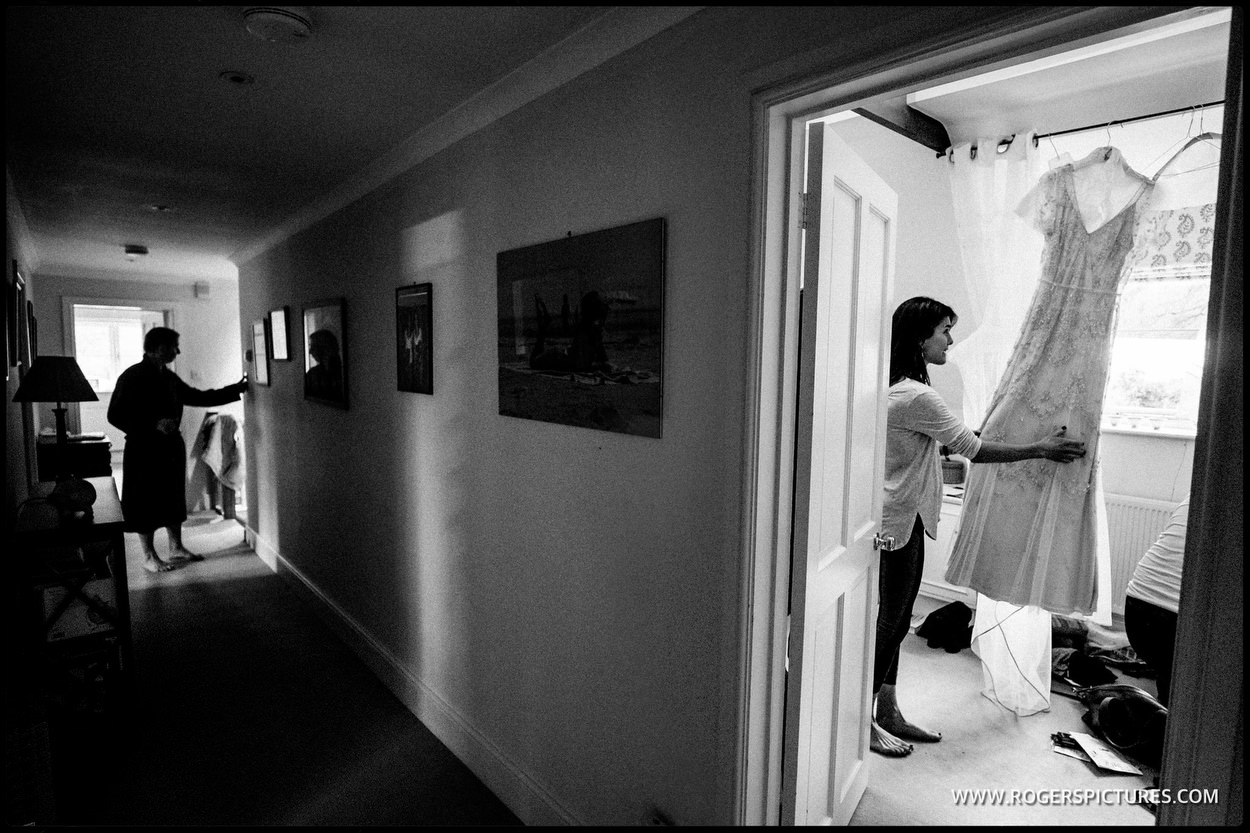 A Bridesmaid looks at the brides hanging wedding dress