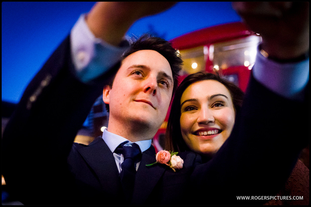 Bride and groom selfie in front of London wedding bus