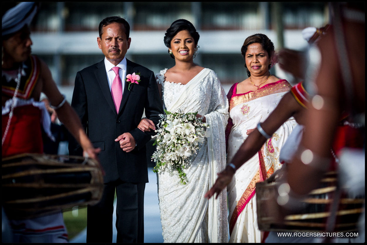 Bride and parents walk down the aisle at a destination wedding in Sri Lanka