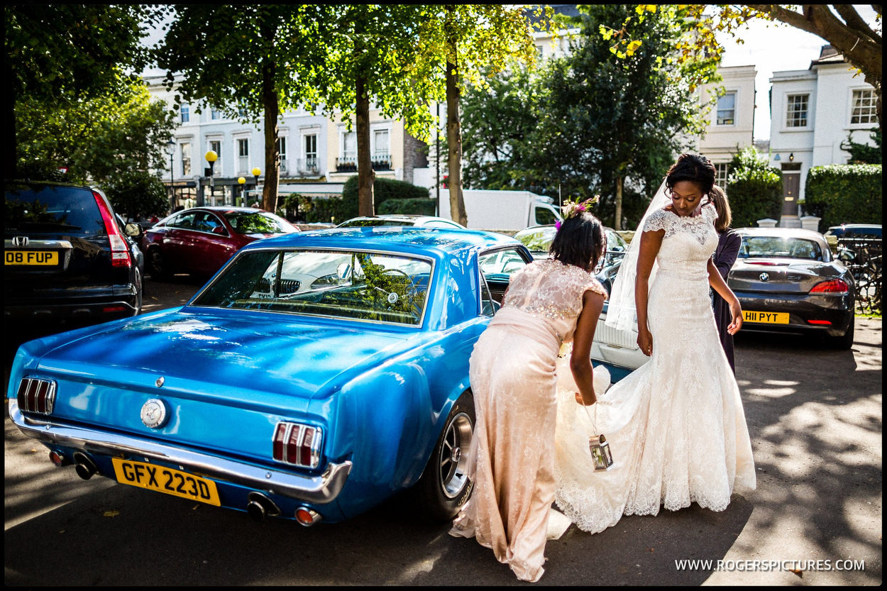 Bride stepping out of a blue Mustang