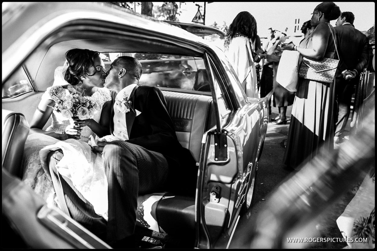 Bride and groom kiss in wedding car