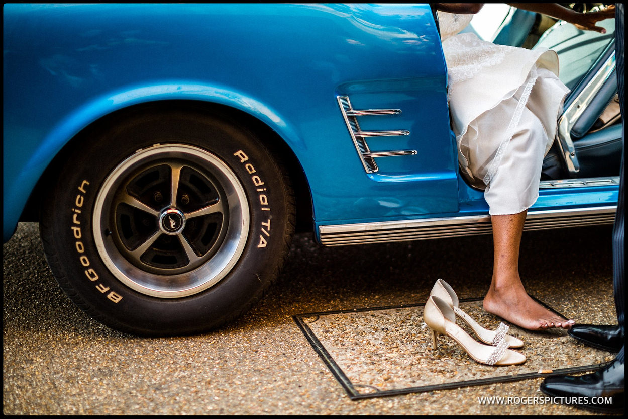 Bride steps out of blue Mustang wedding car