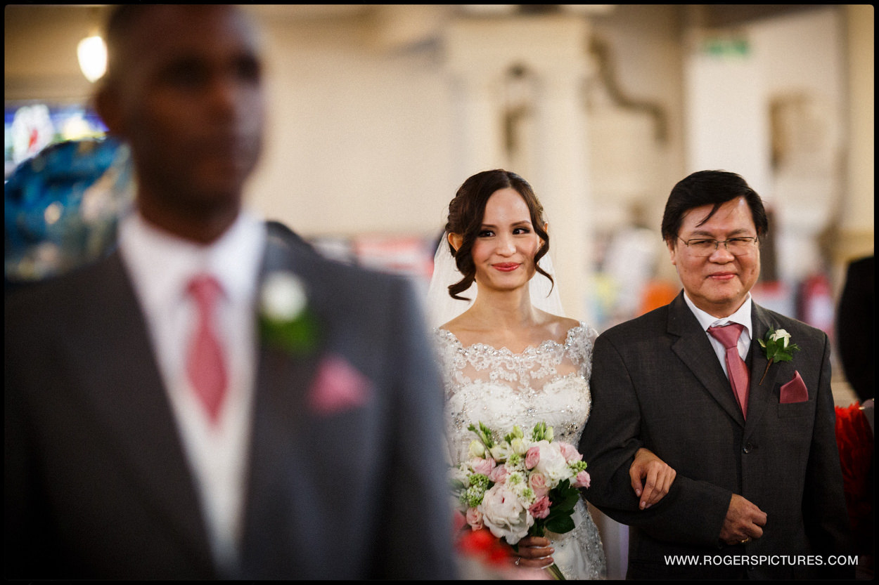 Bride smiles as she approaches groom