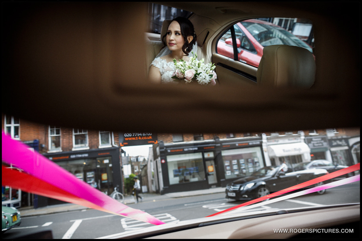 Bride reflected in a car mirror in North London
