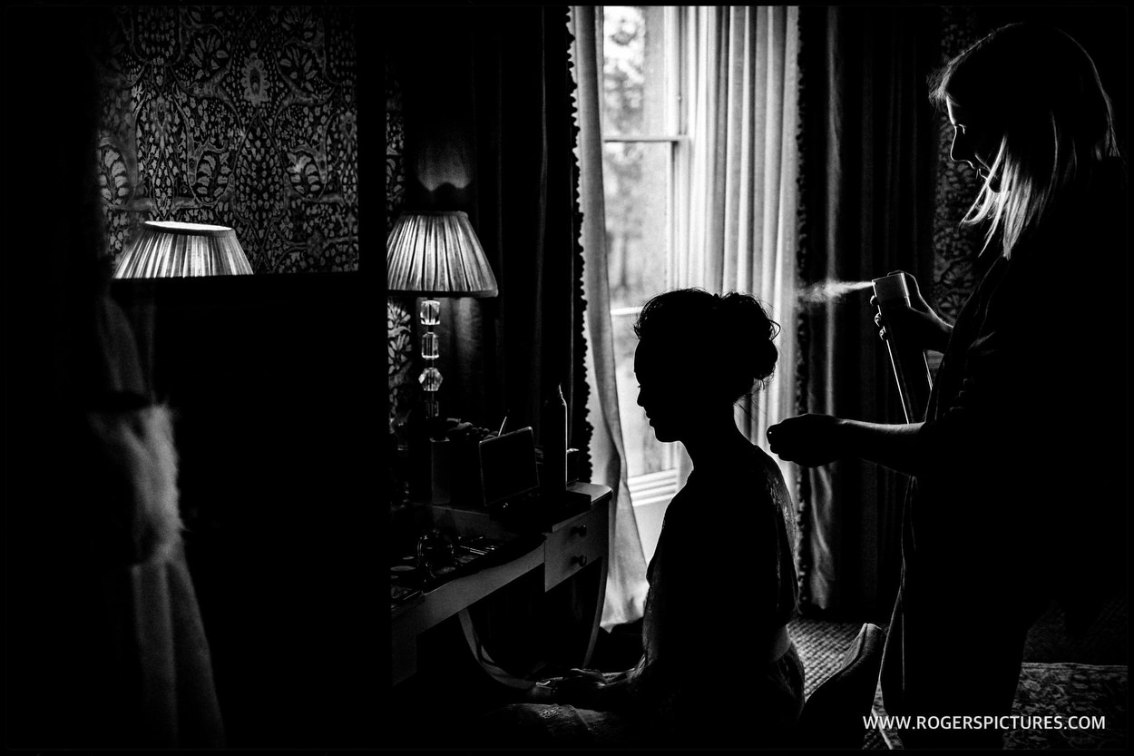 Silhouette photograph of a bride getting ready at Babington House near Frome.