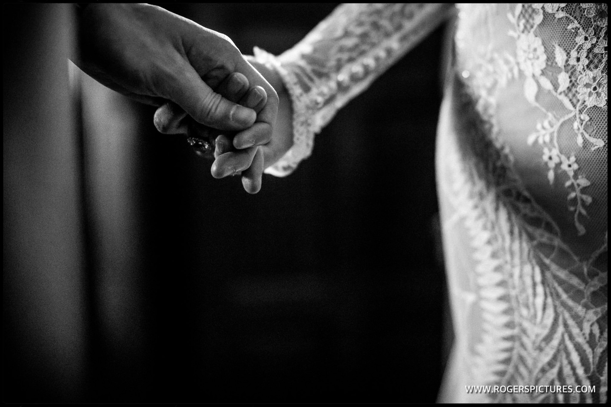 Couple holding hands during the wedding service
