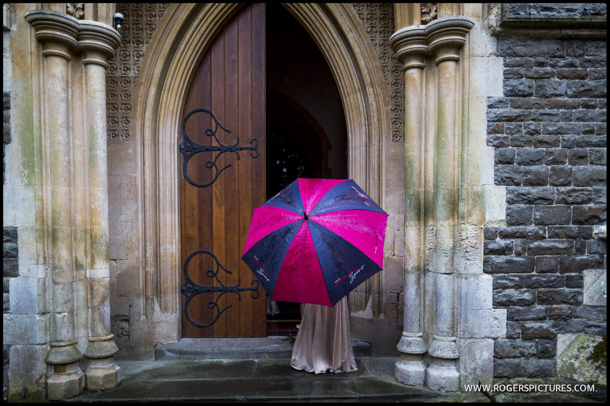 Black and red umbrella at a church door before wedding