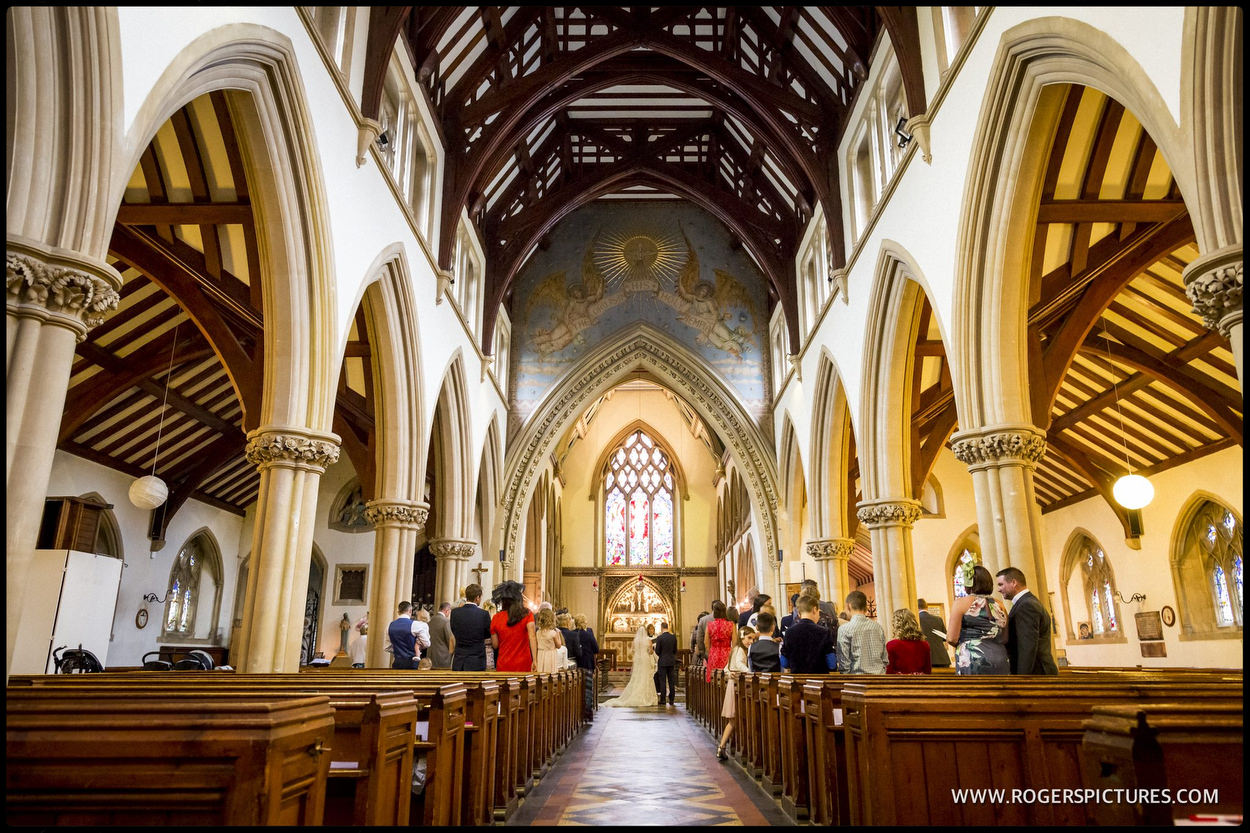 White photograph of interior of church during wedding ceremony