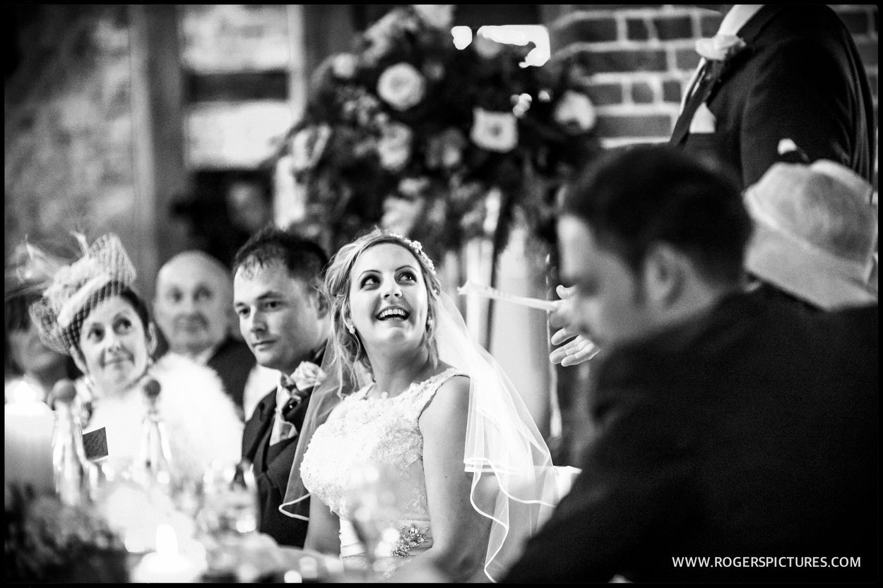 Bride listens to speeches in a barn