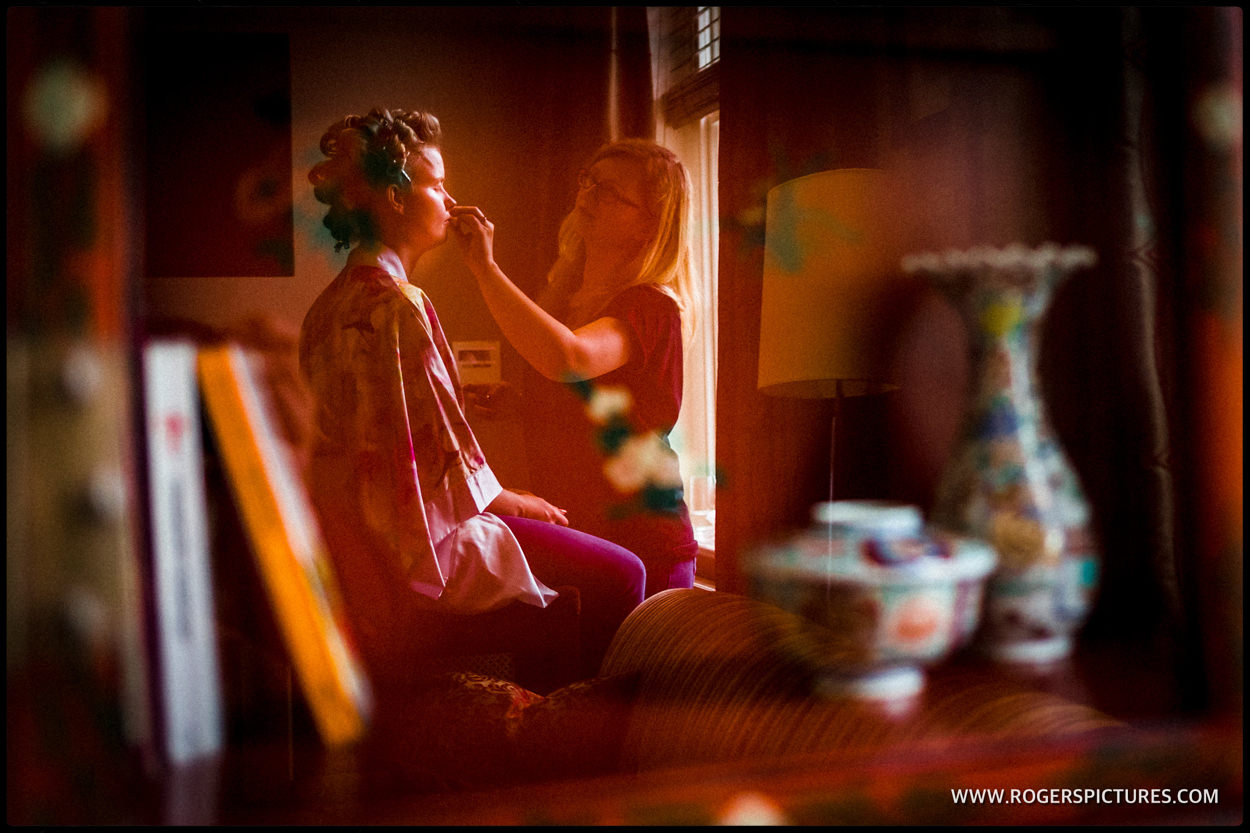 Bride reflected in a window during preparations