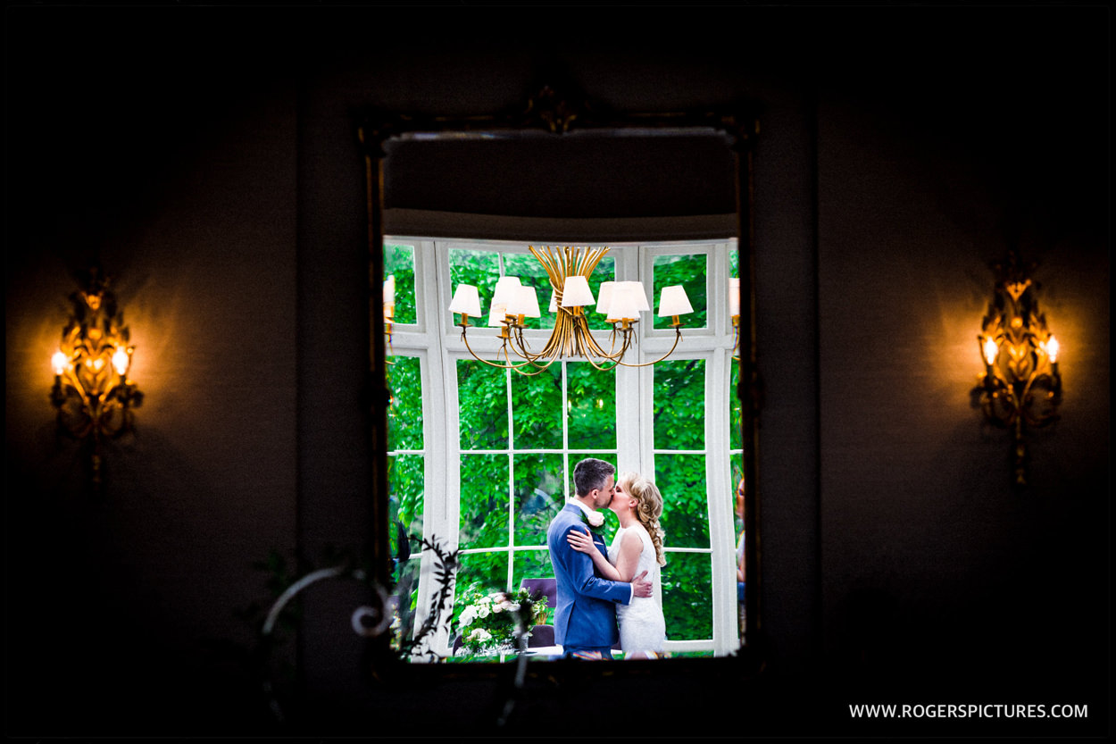 Reflection of bride and groom kissing after wedding ceremony