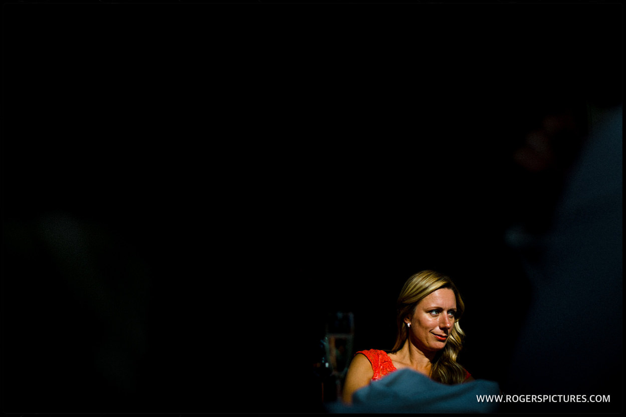 Lady in shaft of sunlight during wedding speeches