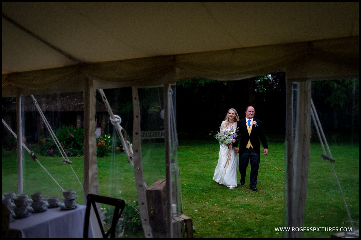 Bride and groom seen framed in the doorway of a wedding tent