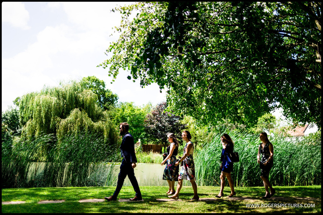 Wedding guests near the lake at Minstrel Court wedding in Hertfordshire