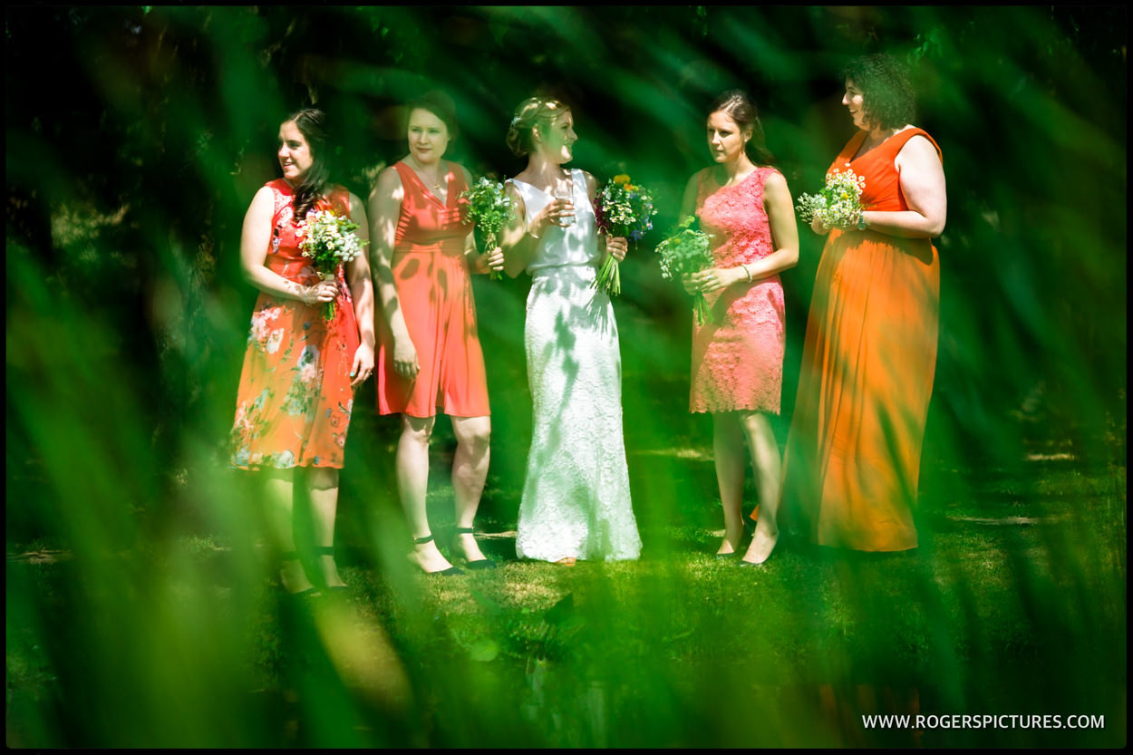 Bride and bridesmaids by the lake at Minstrel Court wedding