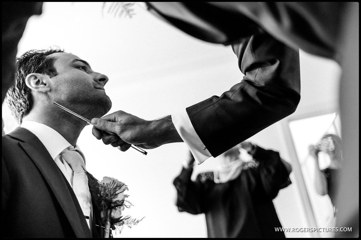 Best man shaving a groom at the Stolisma at a Greek Cypriot wedding