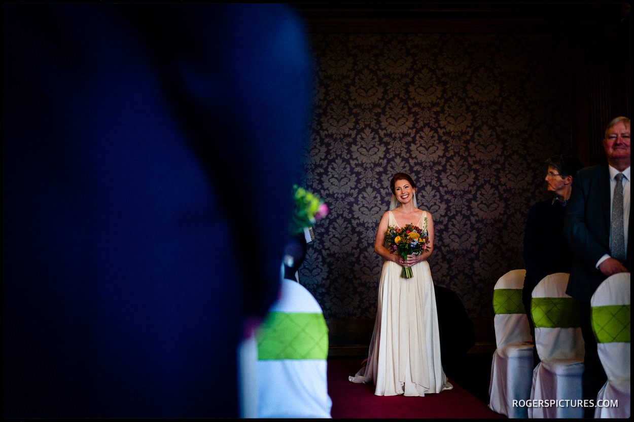 Bride enters ceremony at Nutfield Priory Hotel in Surrey