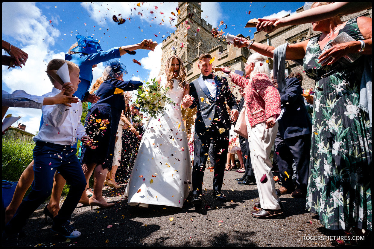 Guests throw confetti after a church ceremony in Waddesdon