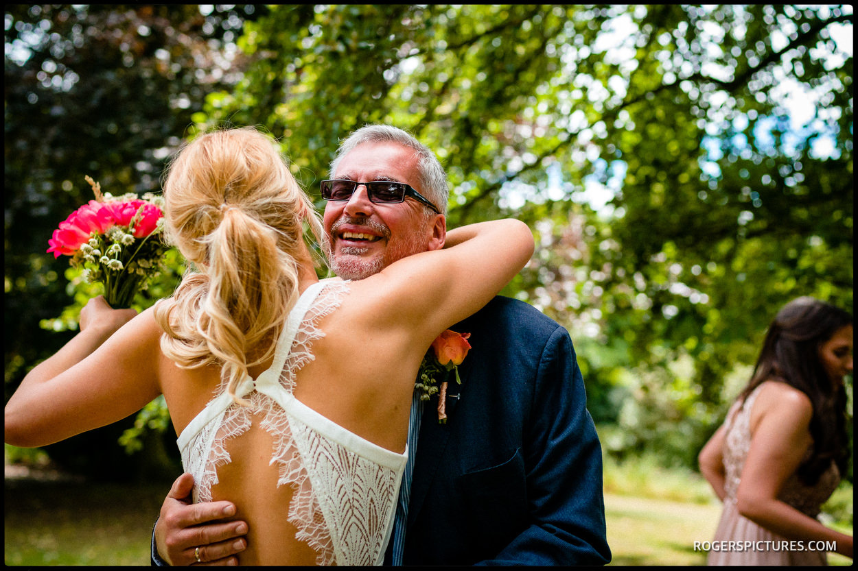 Father hugs his daughter before her North London garden wedding ceremony