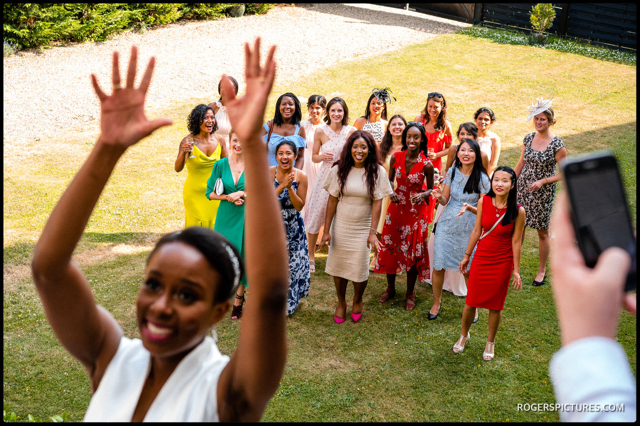 Throwing the bouquet at a Summer wedding at Addington Palace
