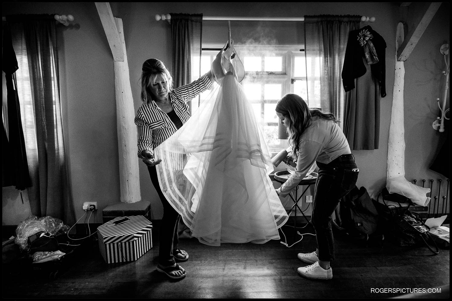 Black and white photo of wedding dress being steamed