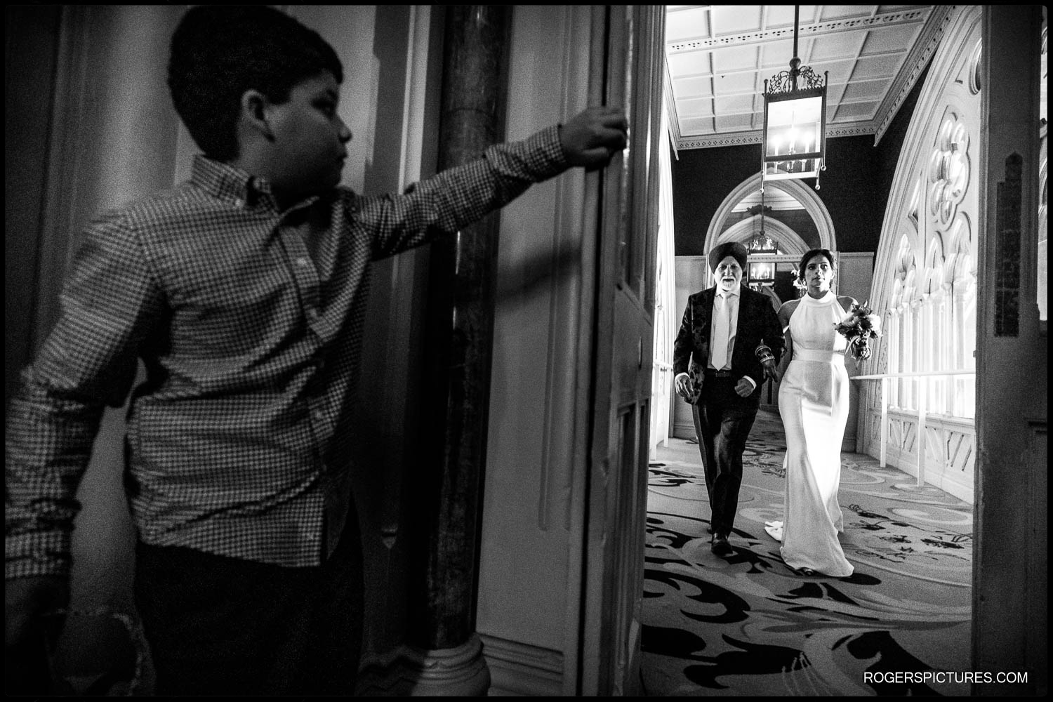 Boy holds door open for Bride and Father on their way to the ceremony