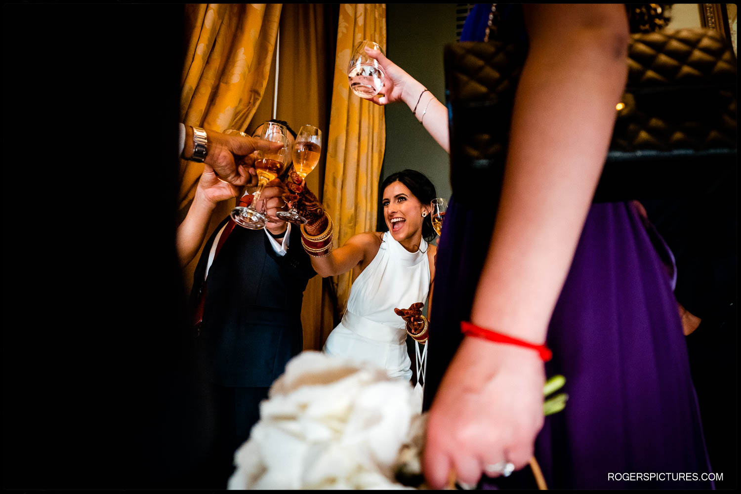Bride drinking champagne with friends