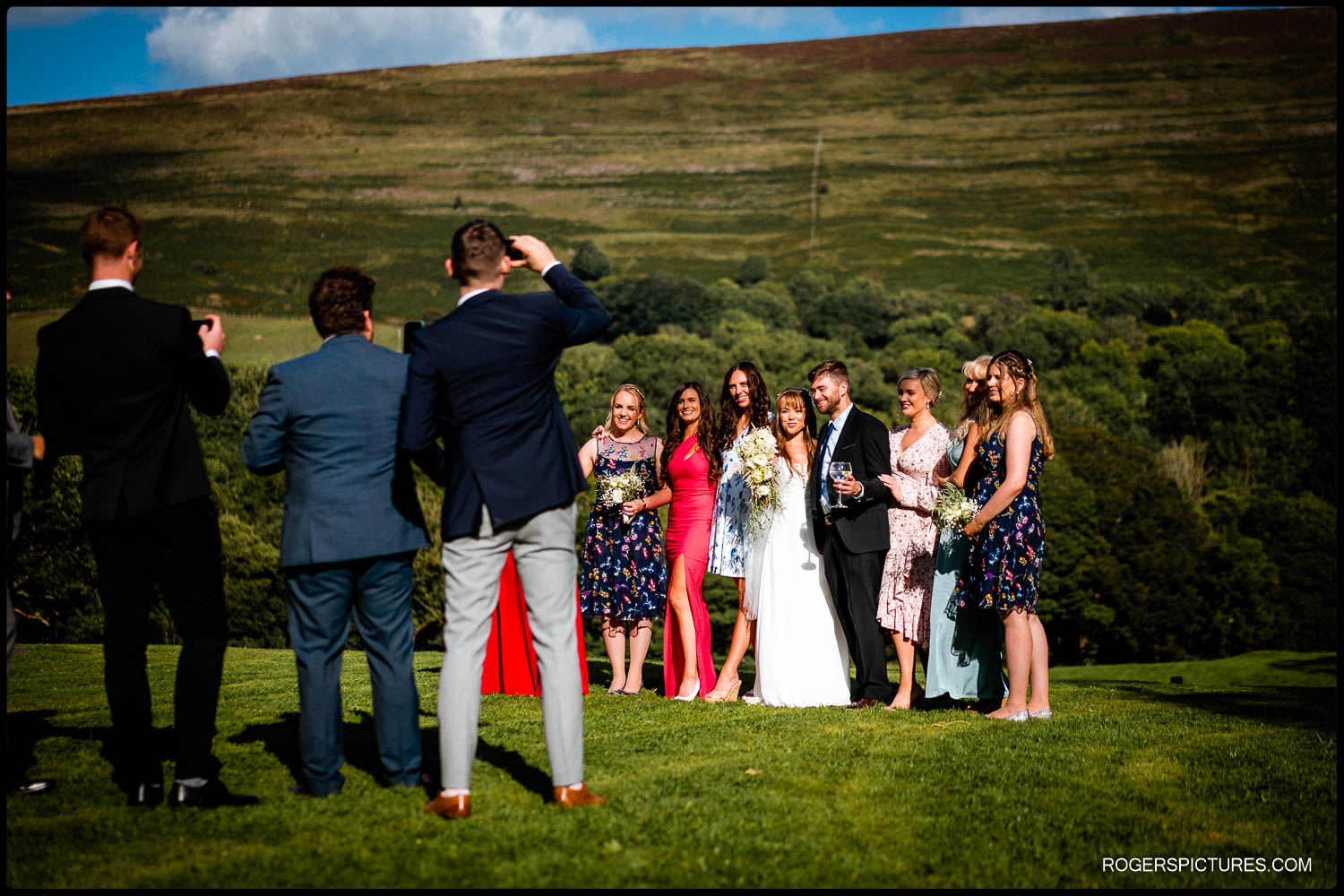 Bride and groom pose with friends in the Peak District