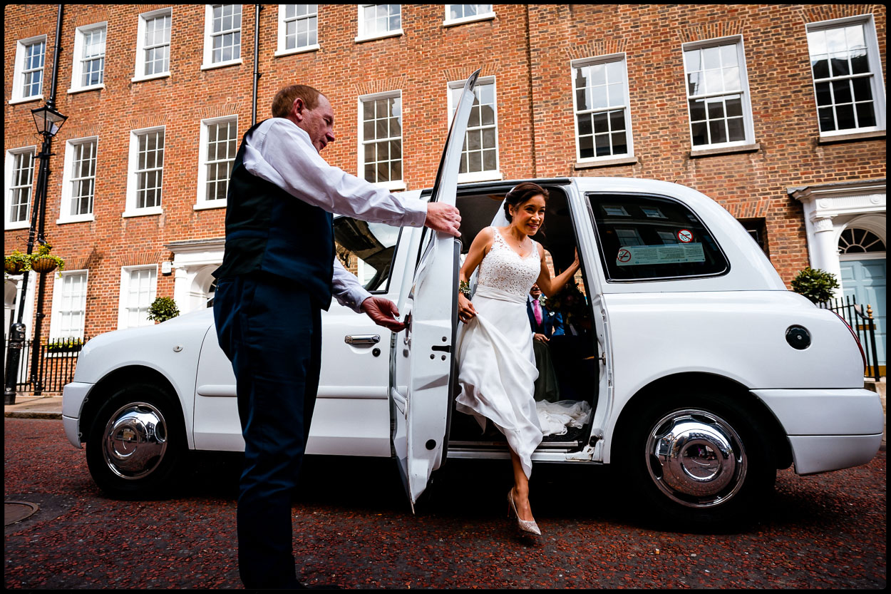 Bride arriving in white London taxi