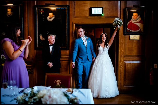 Getting Married at Gray’s Inn 040 Getting Married at Gray's Inn - Grand Reception Entrance – The bride and groom enter their reception, greeted with applause in a wood-paneled banquet hall.