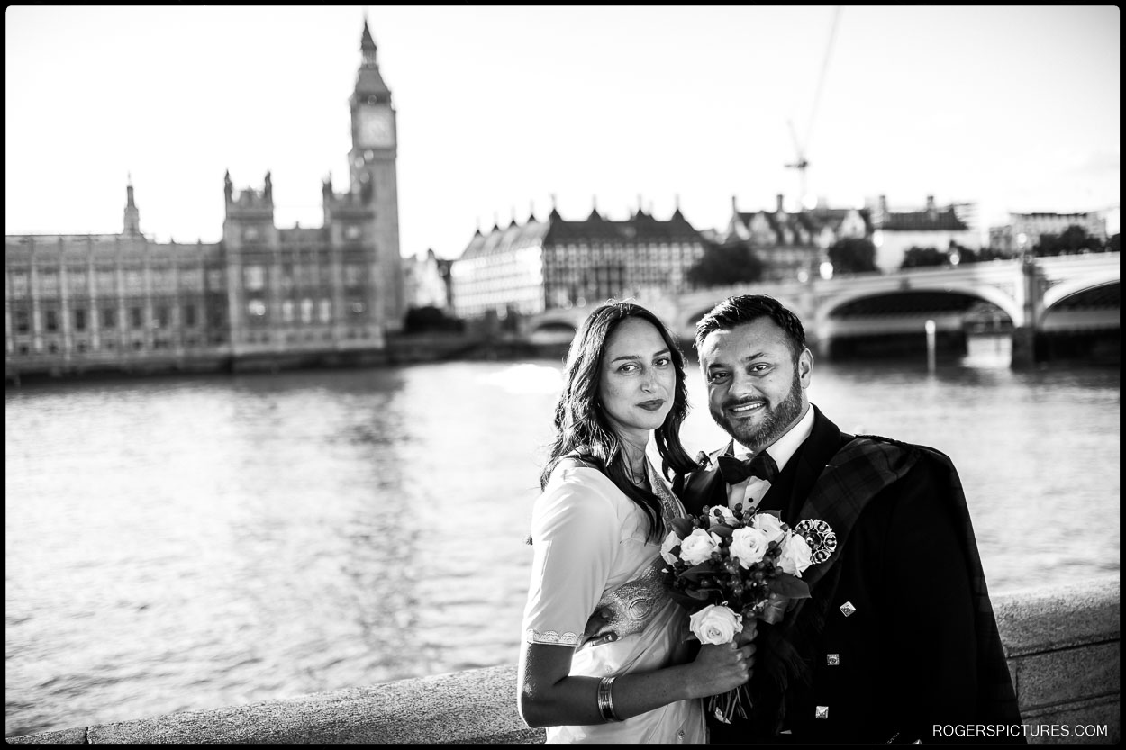Newlyweds pose near Westminster Bridge with Big Ben and the Houses of Parliament in the background after their Short London Wedding.