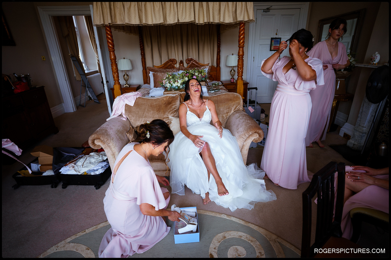 Bride laughing during preparations for wedding at Orchardleigh House