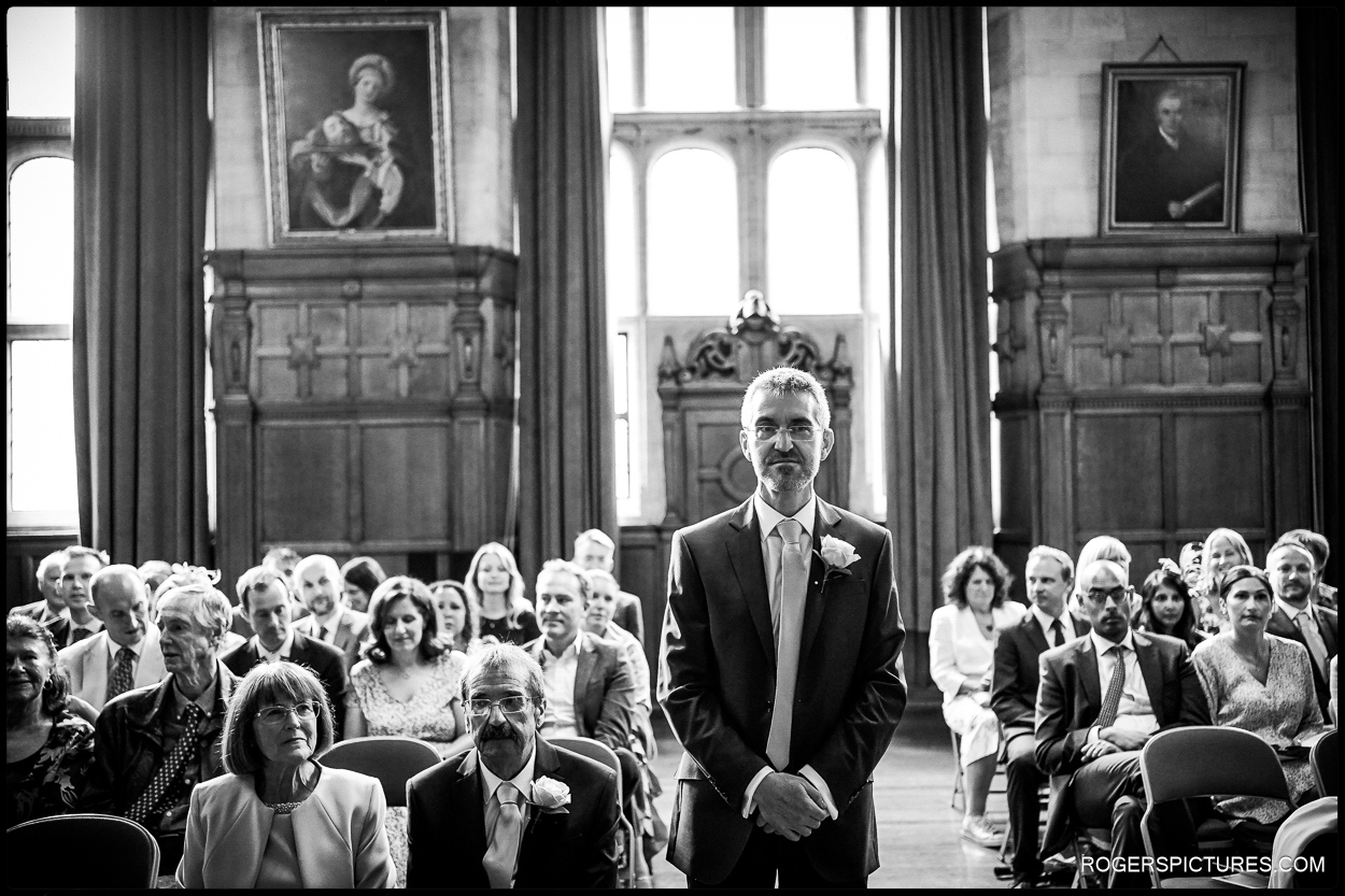 Black and white photo of groom waiting at Oxford Town Hall