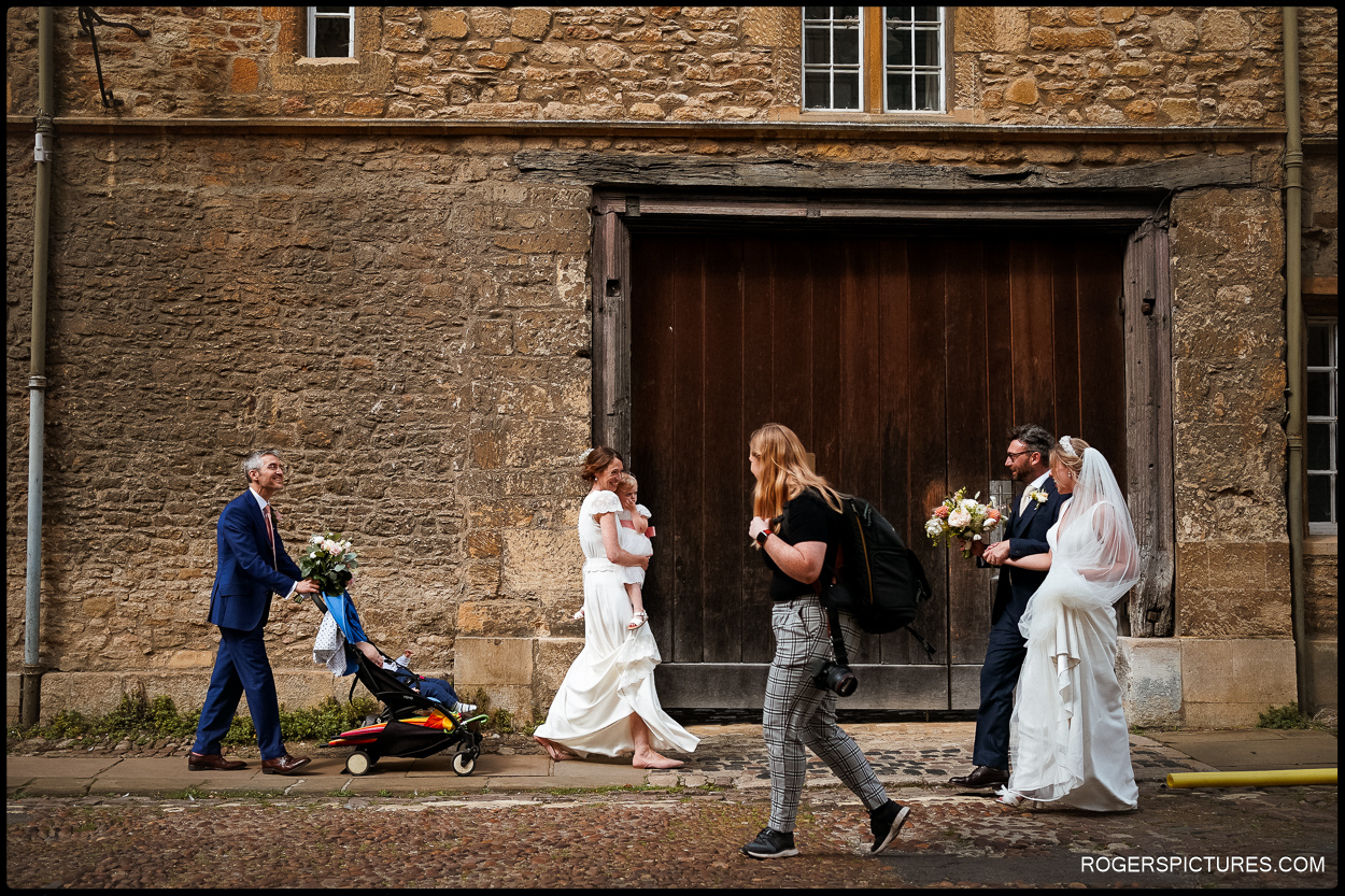 Bride and groom walking on cobbled streets in Oxford
