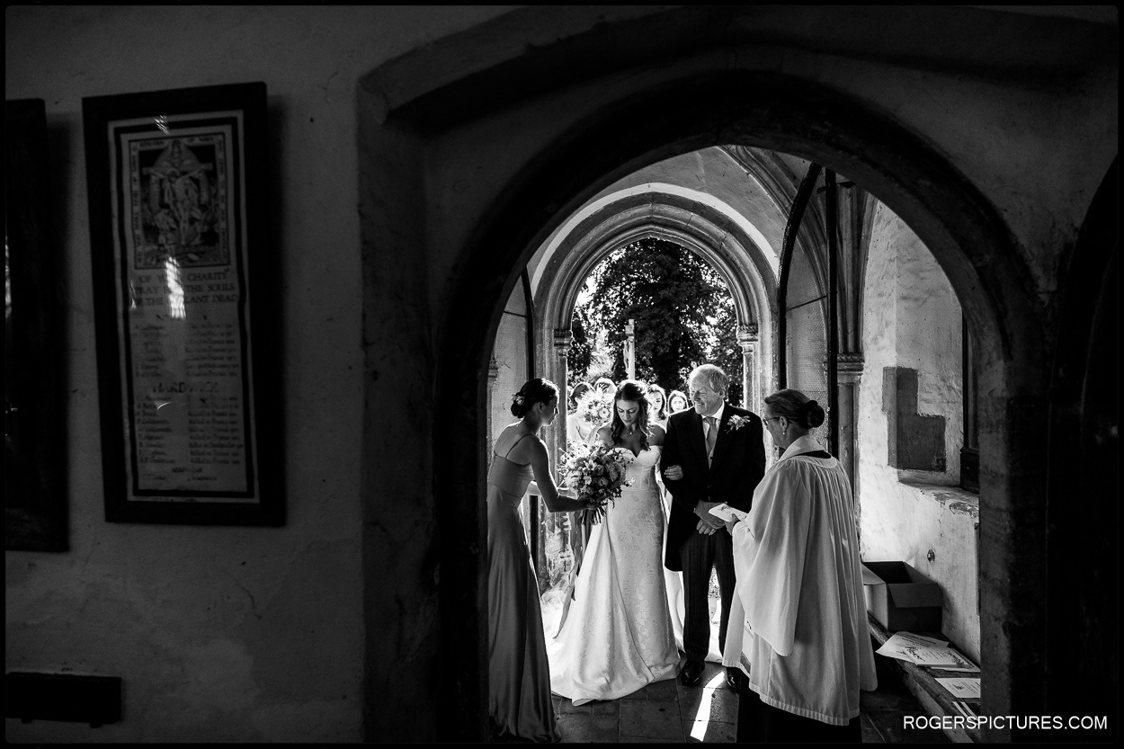 Bride and Father framed in church doorway before wedding ceremony