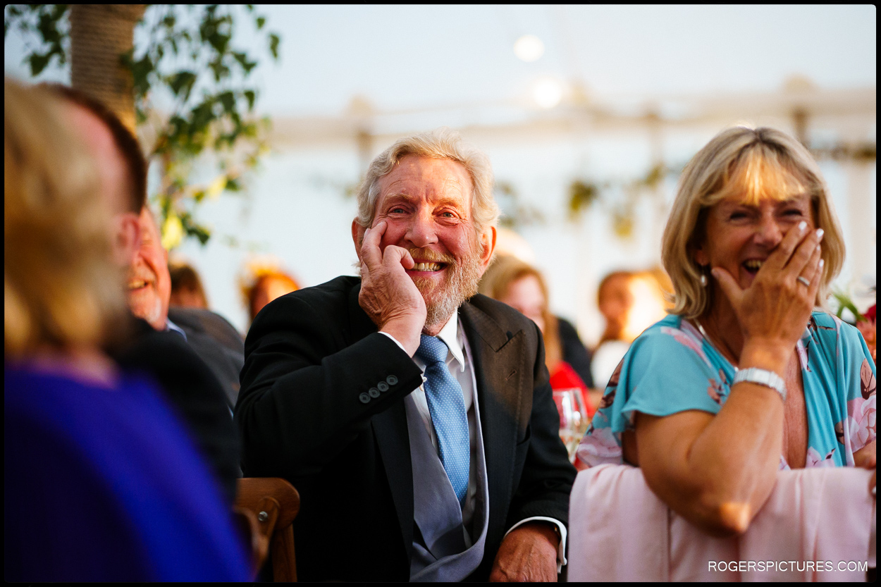 Documentary wedding photography of guests listening to grooms speech