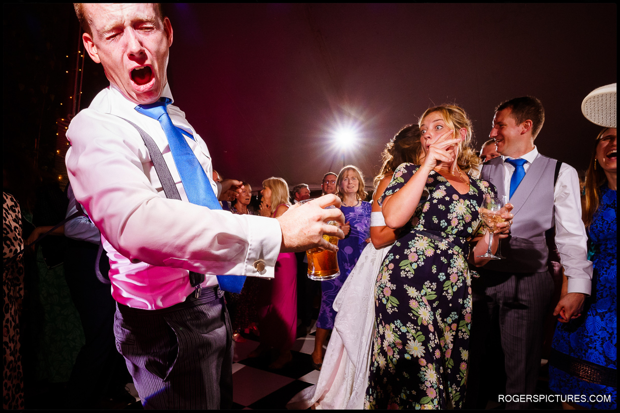 Wedding dance floor action - groom having his braces twanged