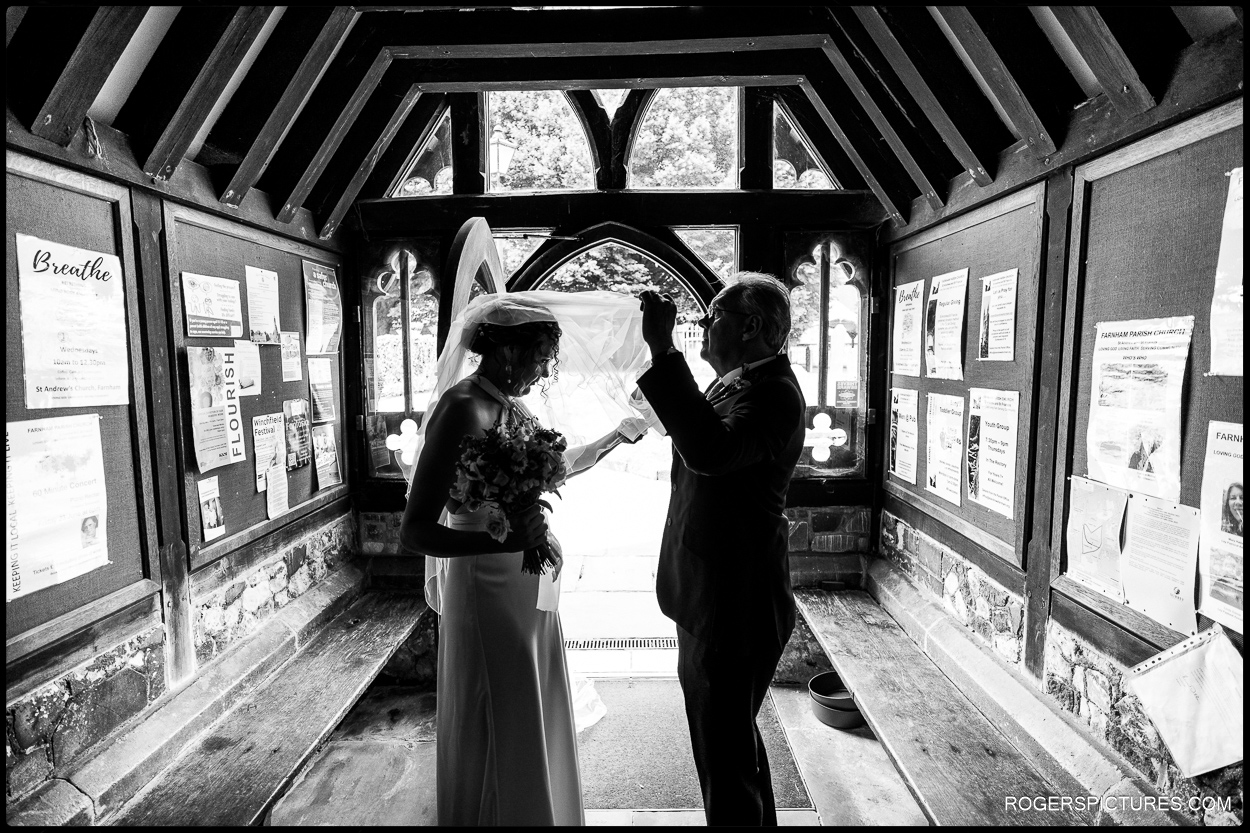 Black and white photo of bride and father arriving at church