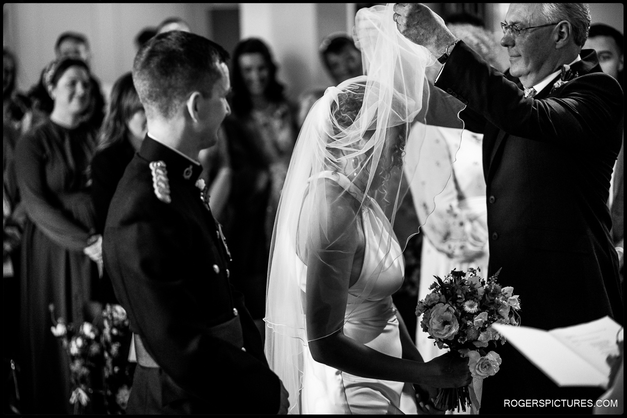 Black and white photograph of father of the bride unveiling his daughter