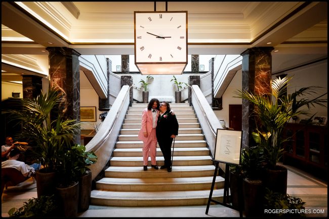 London Wedding at Town Hall Hotel-032 London Wedding at Town Hall Hotel - The couple stands together at the grand staircase of the Town Hall Hotel, framed by elegant Art Deco interiors.