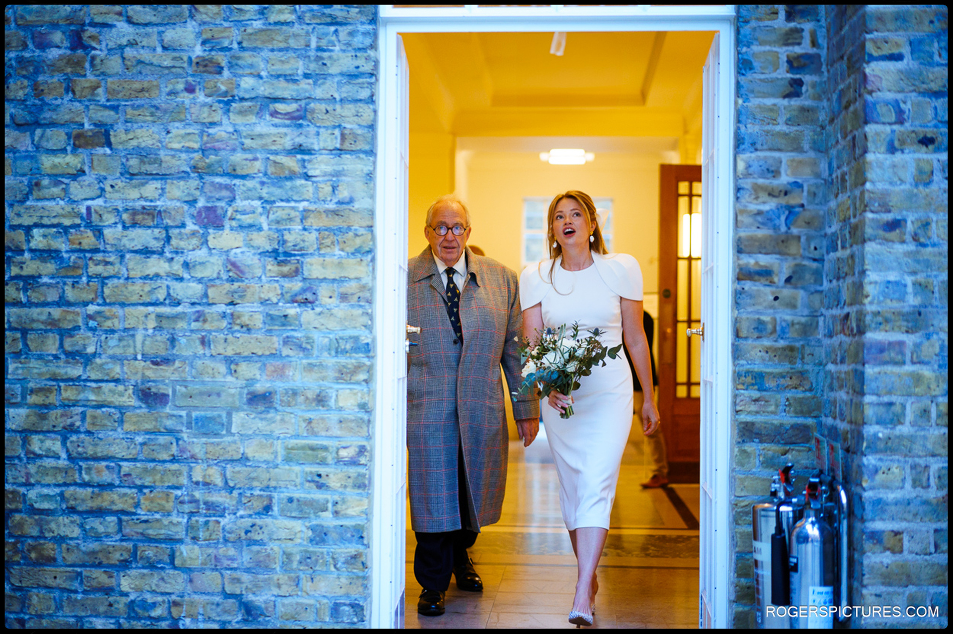 Bride and her father walking into Hackney Town Hall for the wedding ceremony.