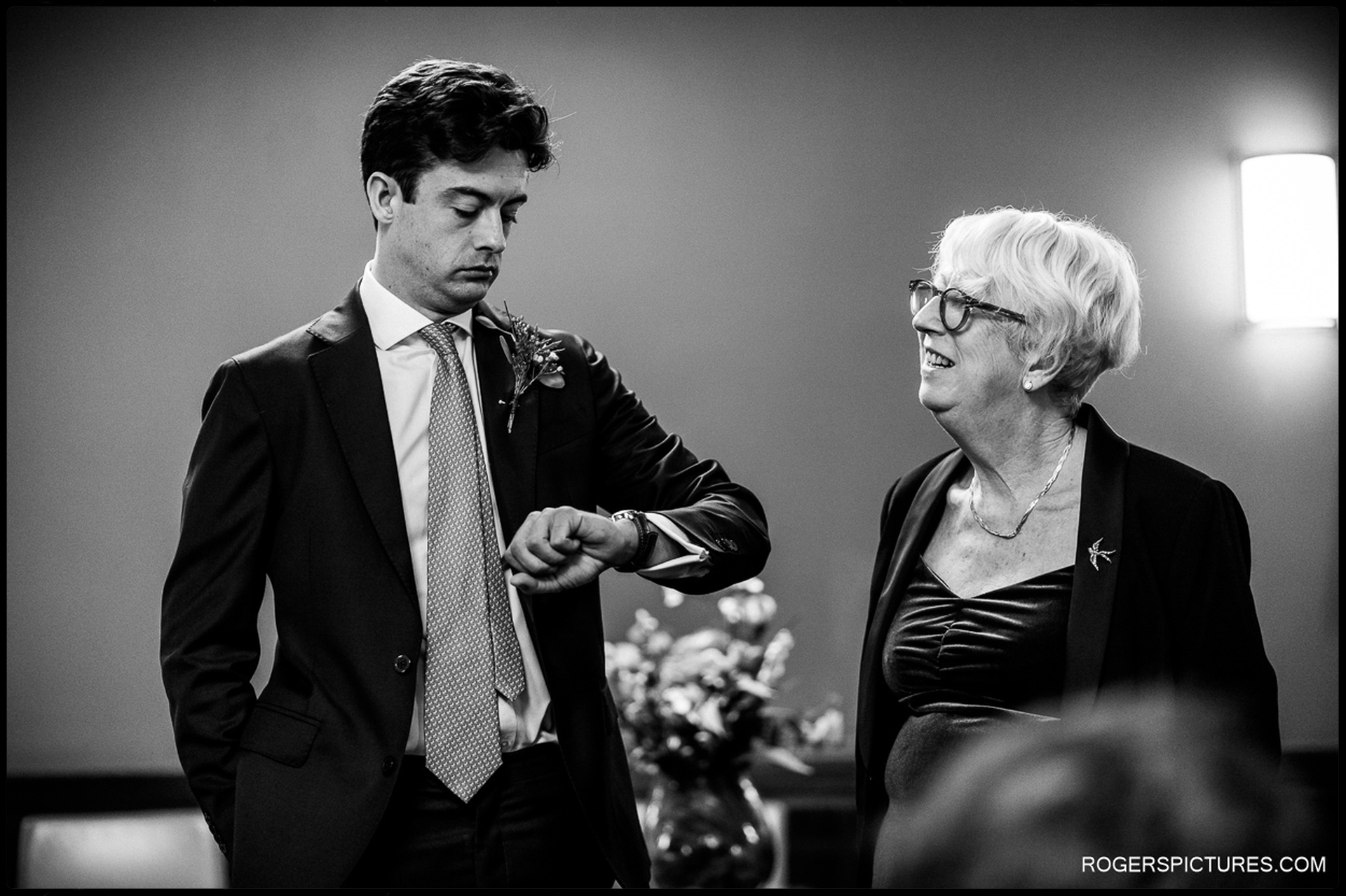 Groom checking his watch while waiting for the ceremony to begin at Hackney Town Hall.