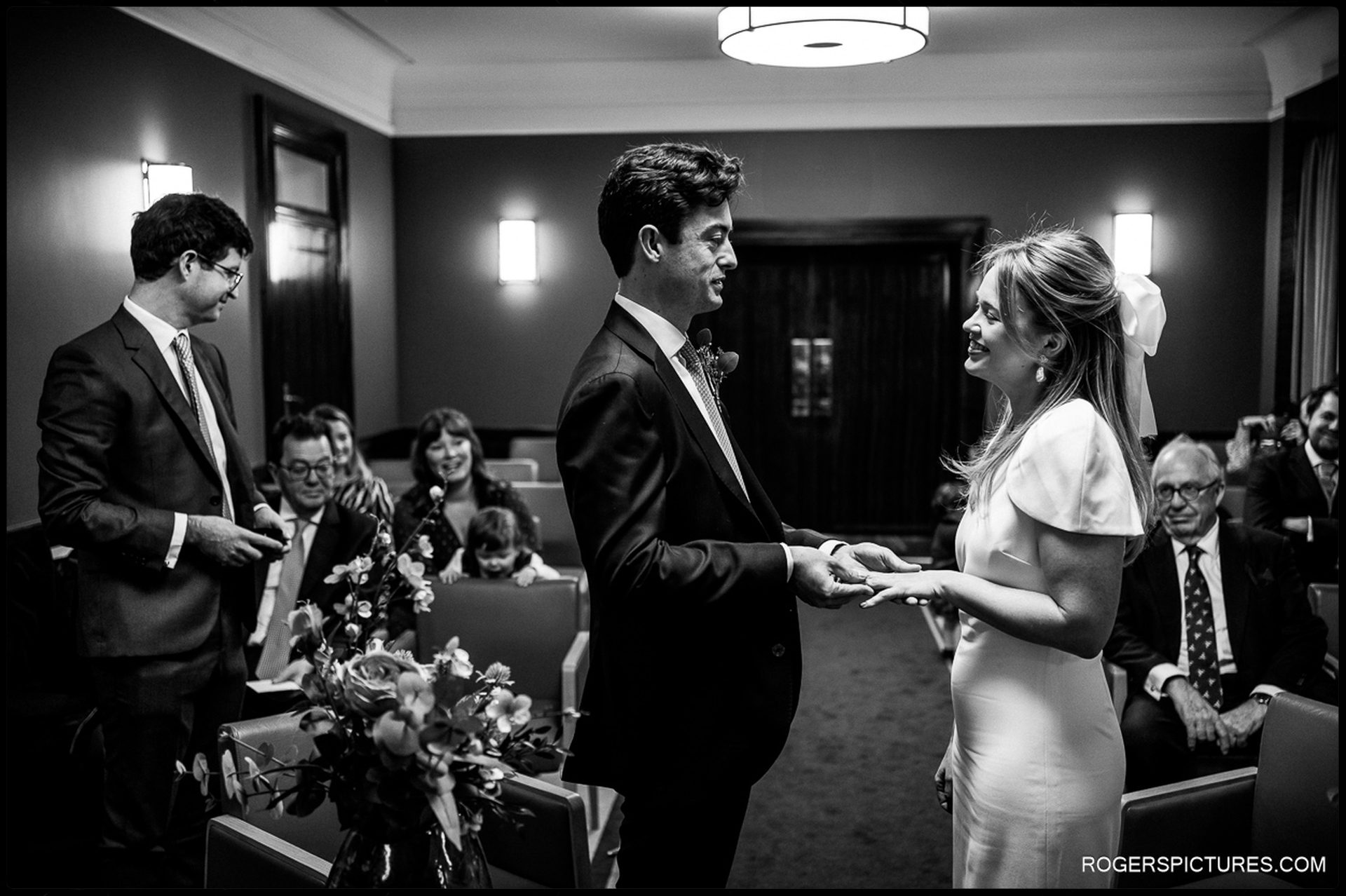 Bride and groom exchange rings during their Short Wedding at Hackney Town Hall, surrounded by family.