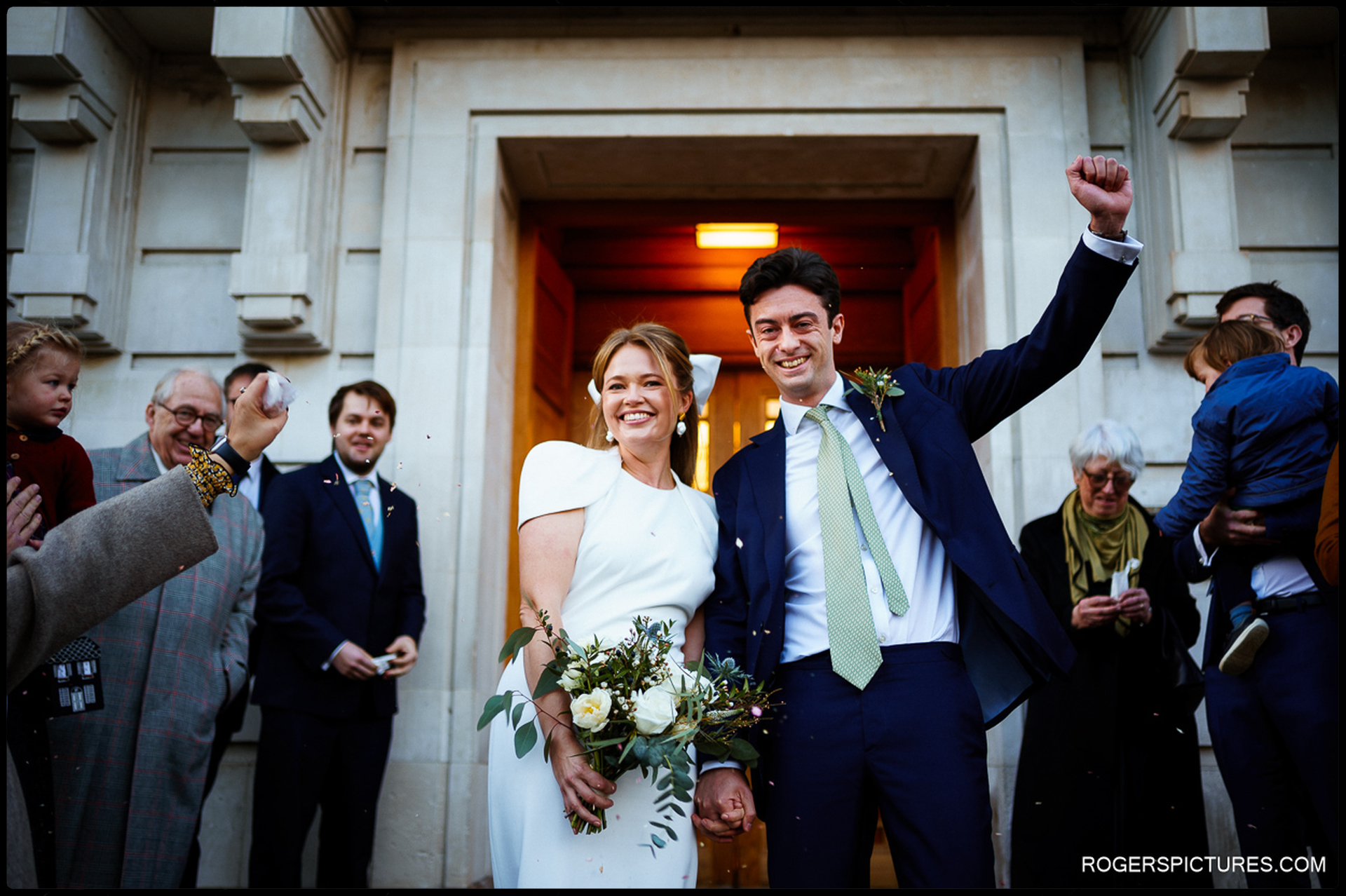 Bride and groom share a joyful moment outside Hackney Town Hall as they celebrate their wedding.