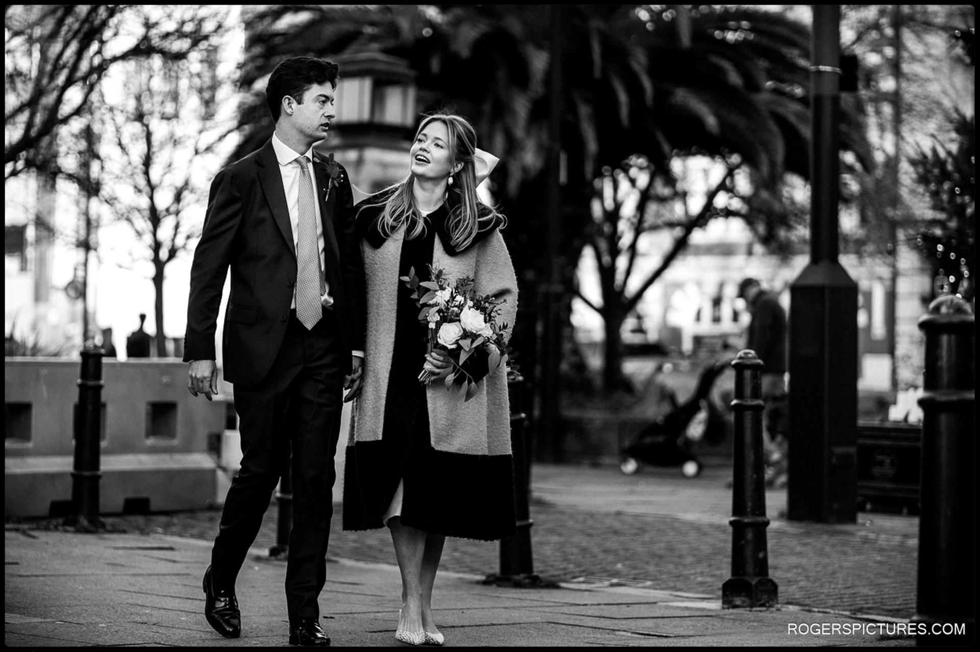 Newlyweds walk together through Hackney after their Short Wedding at Hackney Town Hall.